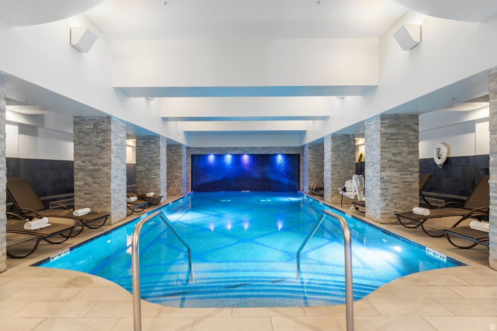 Indoor swimming pool with mosaic tile and blue accent lighting