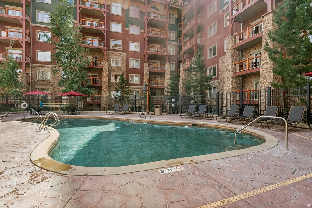 Curved outdoor swimming pool surrounded by stamped concrete decking