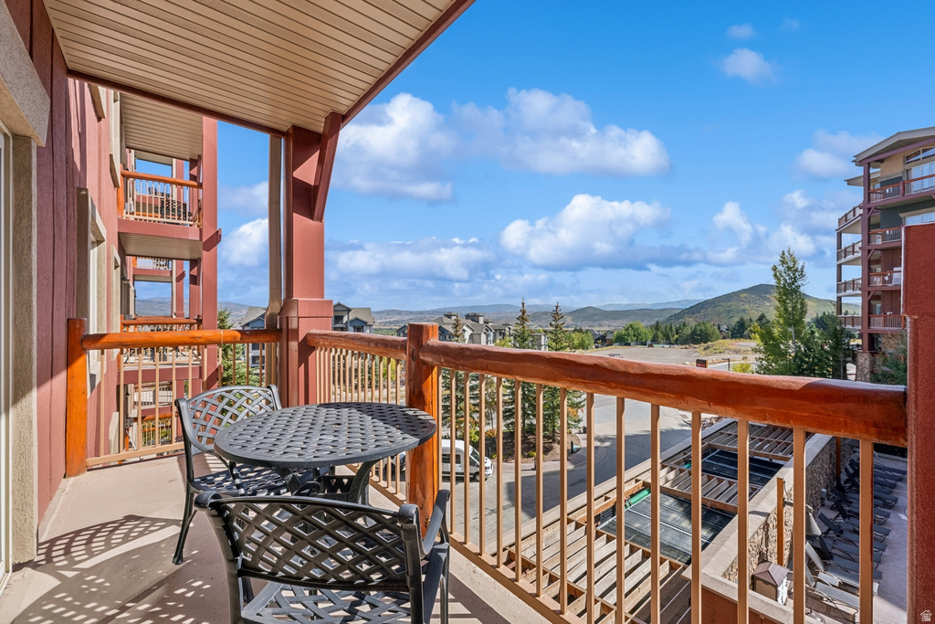 Covered balcony with natural wood railing and red-painted structural beams