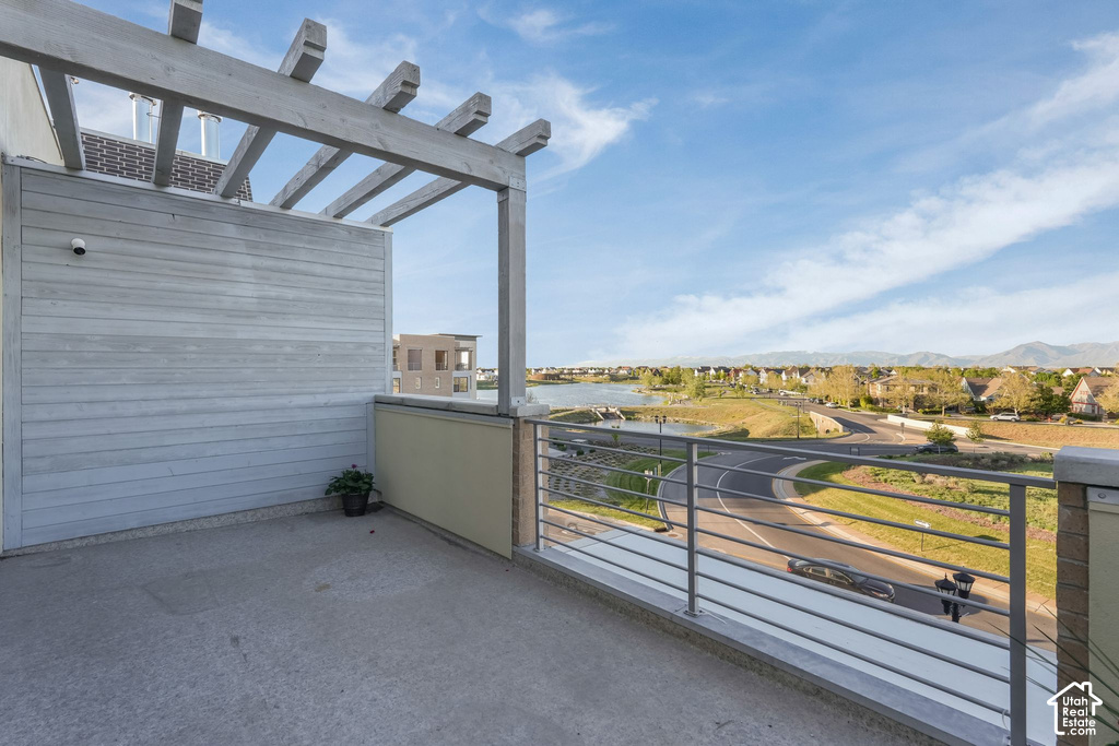 Rooftop patio with a concrete surface, wooden pergola, and horizontal metal railings
