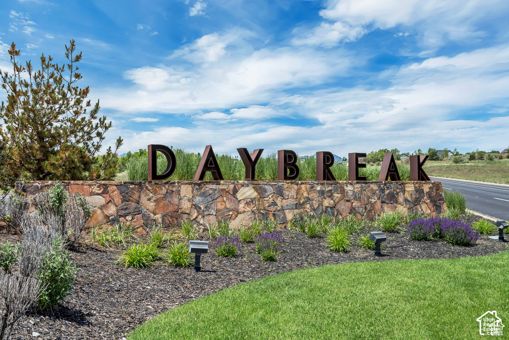 Stone-clad monument signage featuring dimensional lettering and integrated landscape lighting