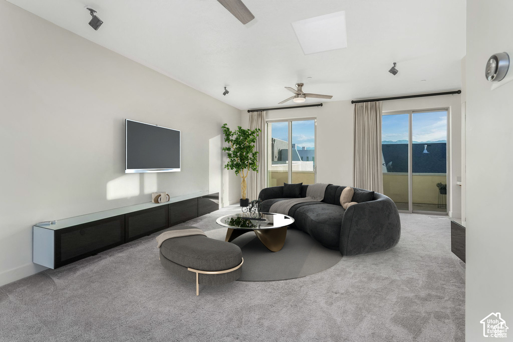 Spacious living area featuring light gray carpeting, a built-in media console, multiple sliding glass doors, a ceiling fan, and recessed lighting