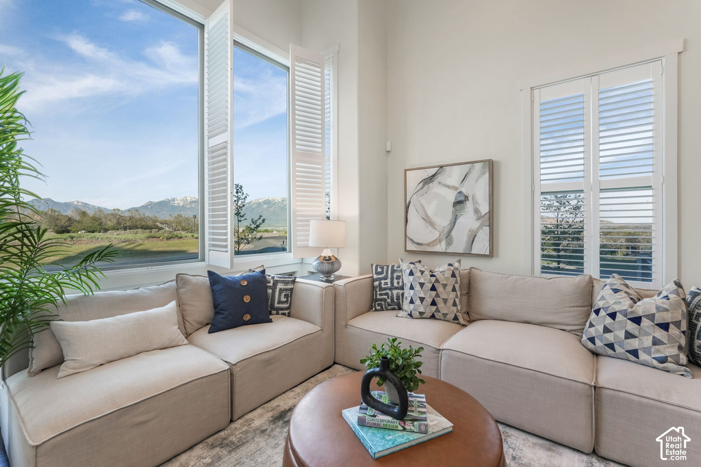 Interior space featuring an expansive window with white plantation shutters, providing abundant natural light and exterior scenery