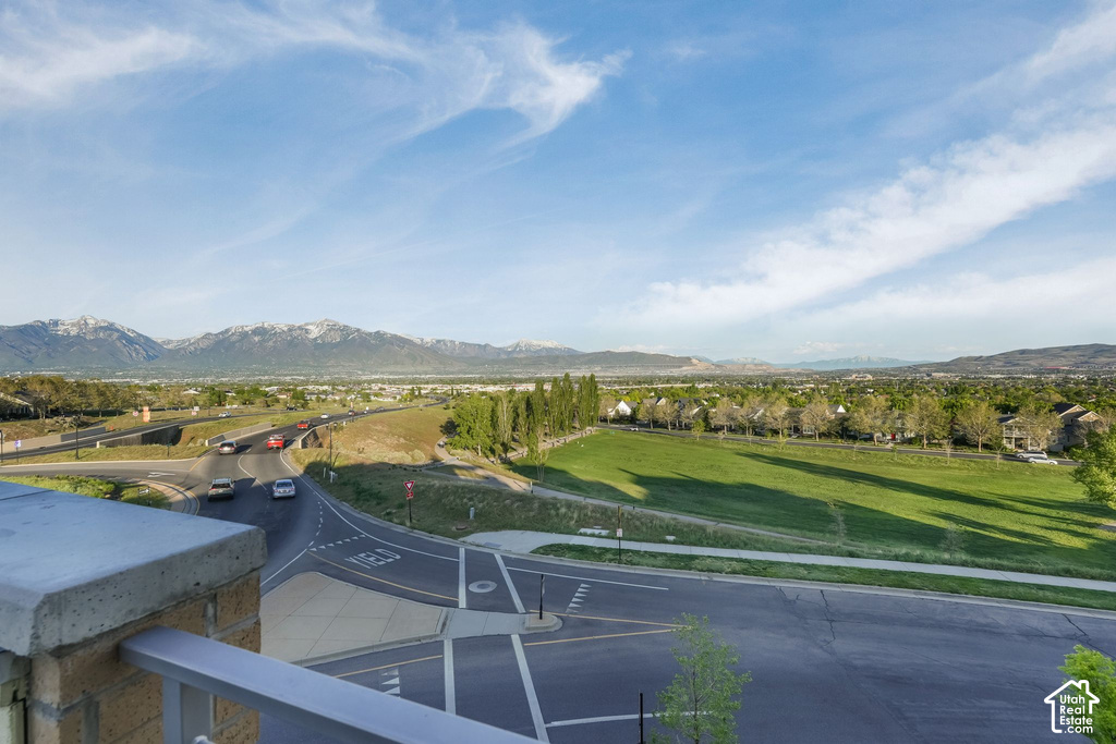 Expansive landscape featuring snow-capped mountains, a broad valley, and a vibrant green field