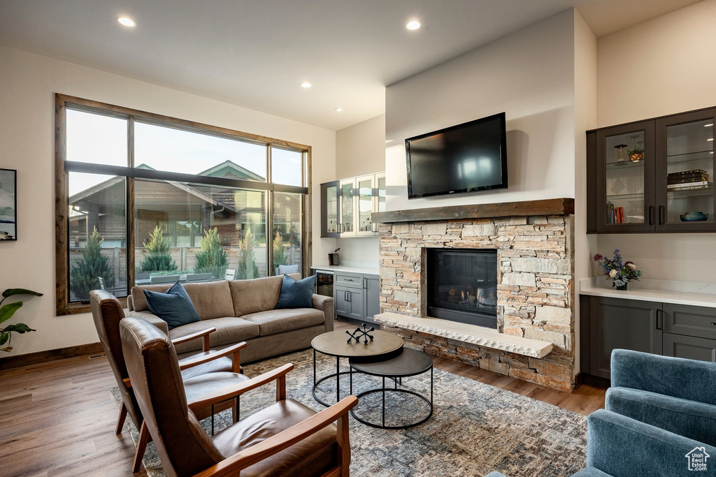 Spacious living area featuring a stacked stone fireplace with a substantial wood mantel, a stone hearth, and integrated media space