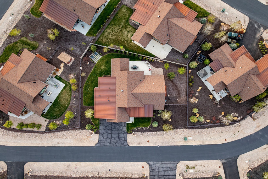 Aerial perspective showcasing a residential property with a brown shingle roof and a private driveway