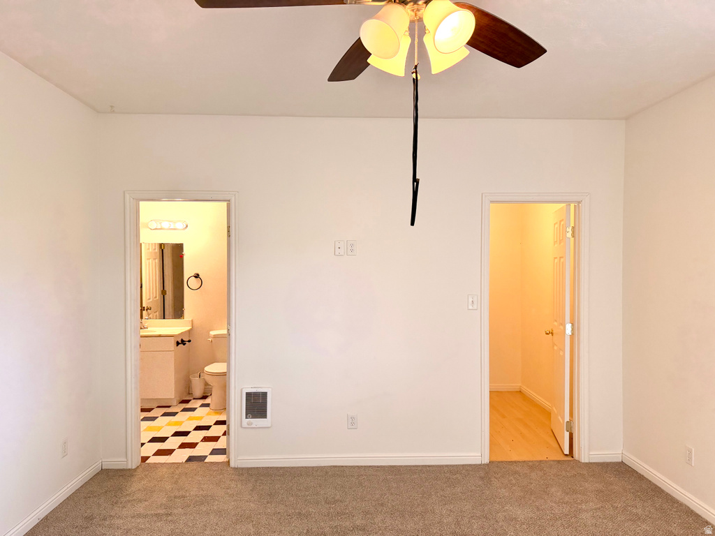 Carpeted room featuring a ceiling fan with integrated lighting, two doorways, and white wall finishes