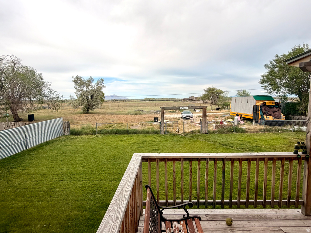 Expansive backyard featuring a green lawn and partial corrugated metal fencing