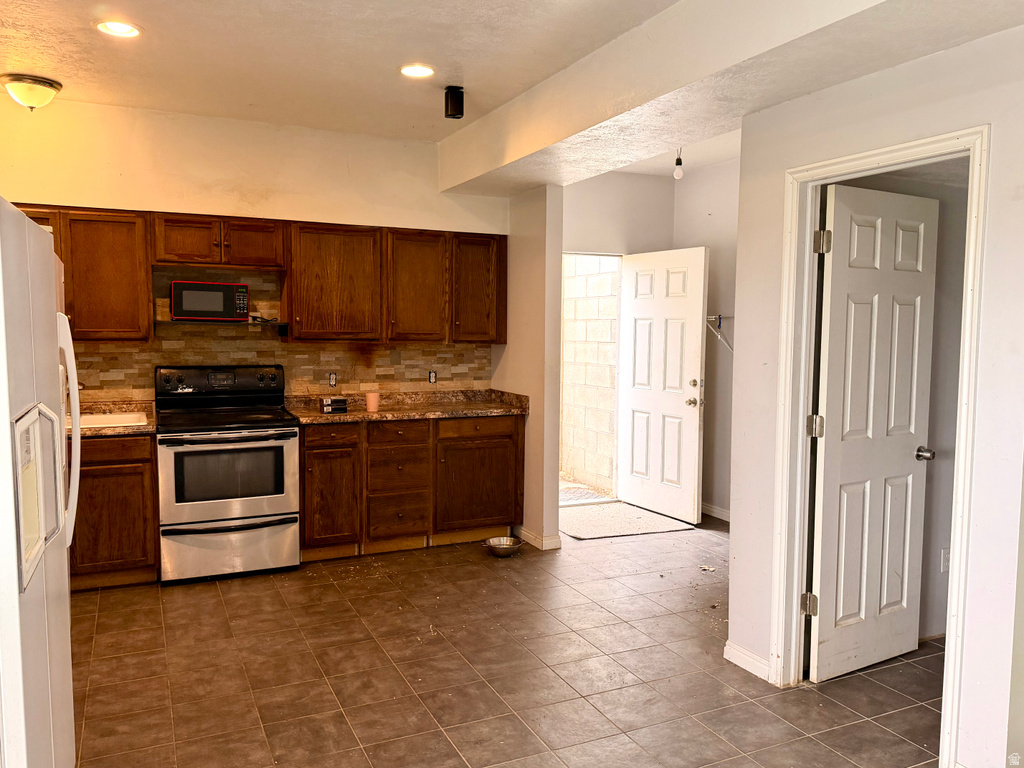 Kitchen area featuring warm wood-finish cabinetry, stainless steel range, and built-in microwave