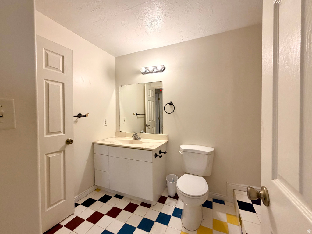 Bathroom featuring a white vanity with a light-colored countertop, an integrated sink, and an overhead vanity light fixture