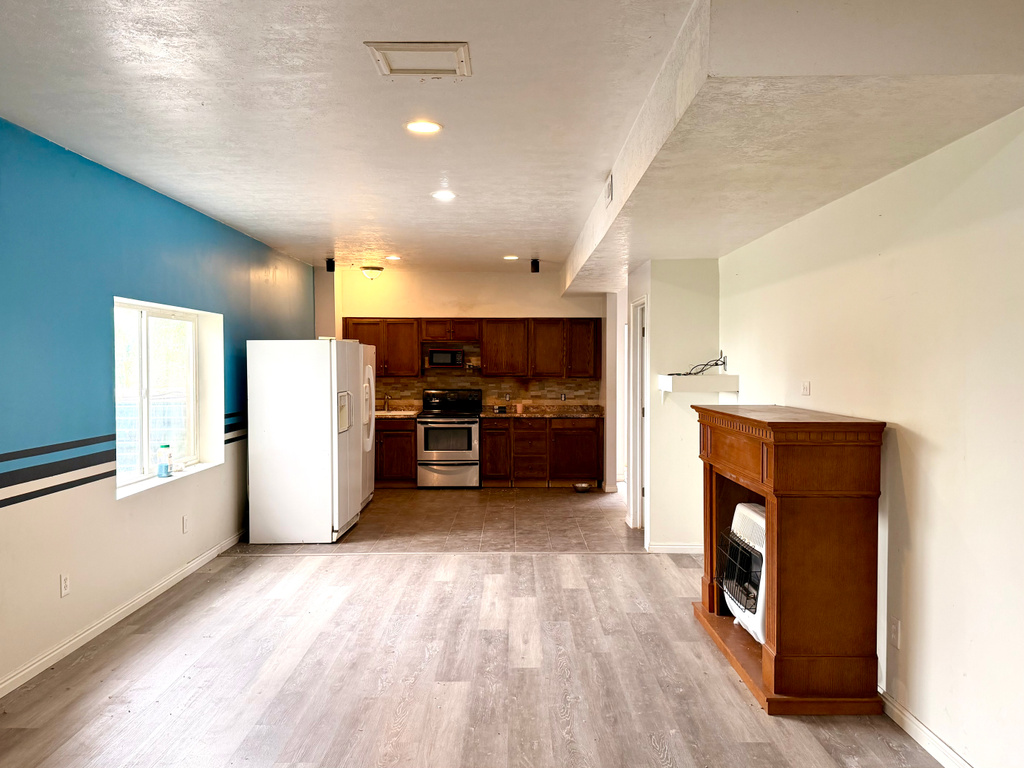Open living area featuring wood-finish flooring, recessed lighting, and a built-in kitchen space
