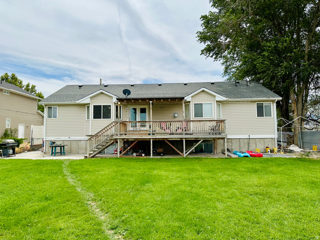 Rear exterior featuring a spacious wooden deck with staircase access to the backyard