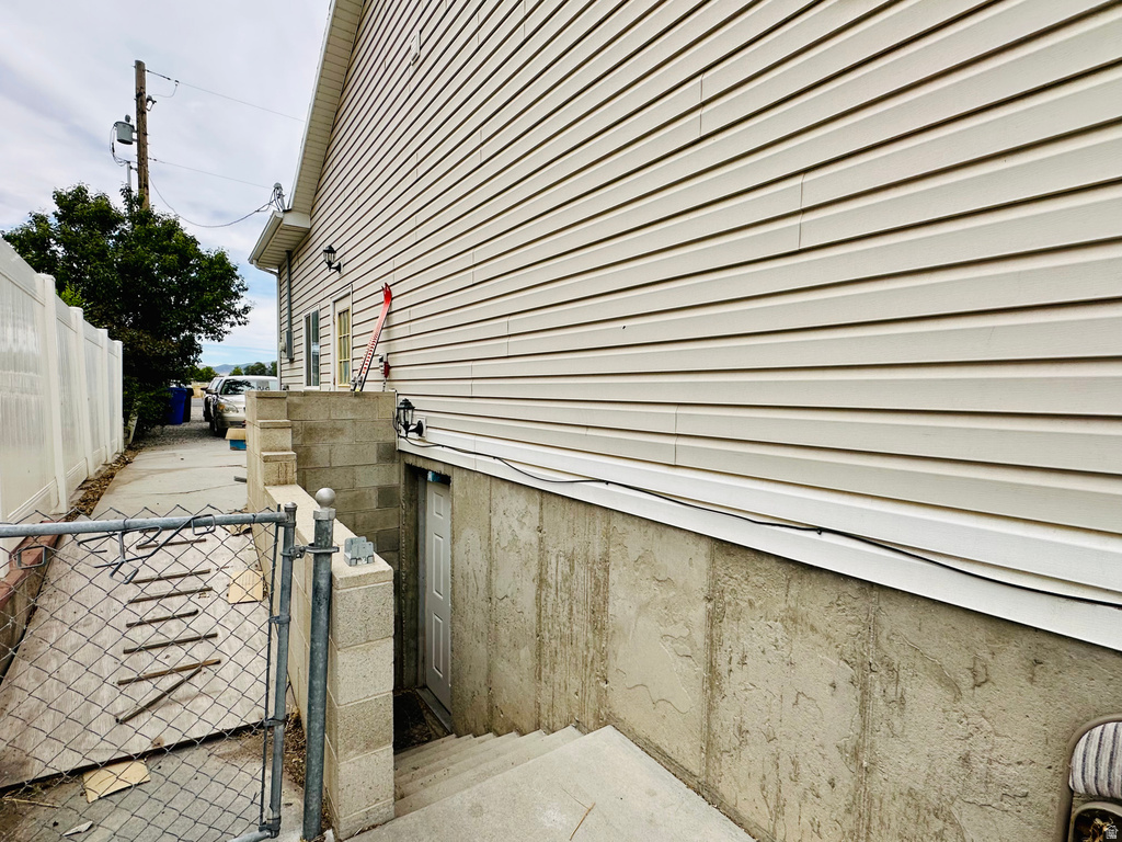 Side exterior featuring light-colored horizontal siding and a concrete foundation