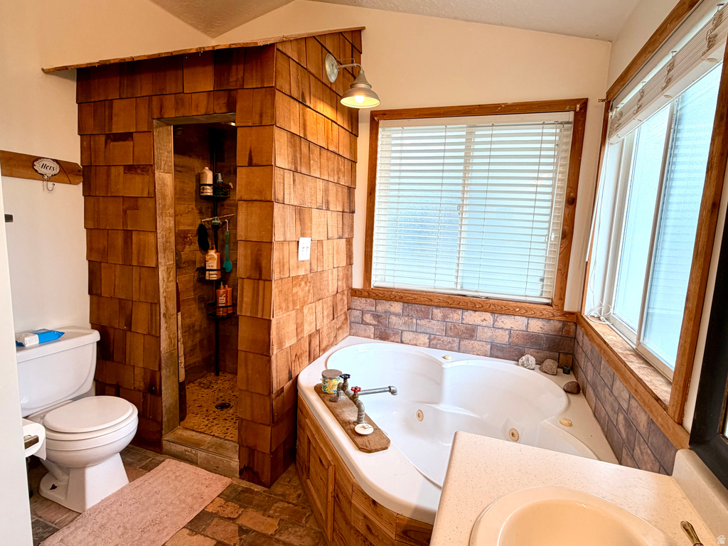Bathroom featuring a jetted soaking tub, a stand-up shower with wood-shingle exterior, and multiple windows with wood trim