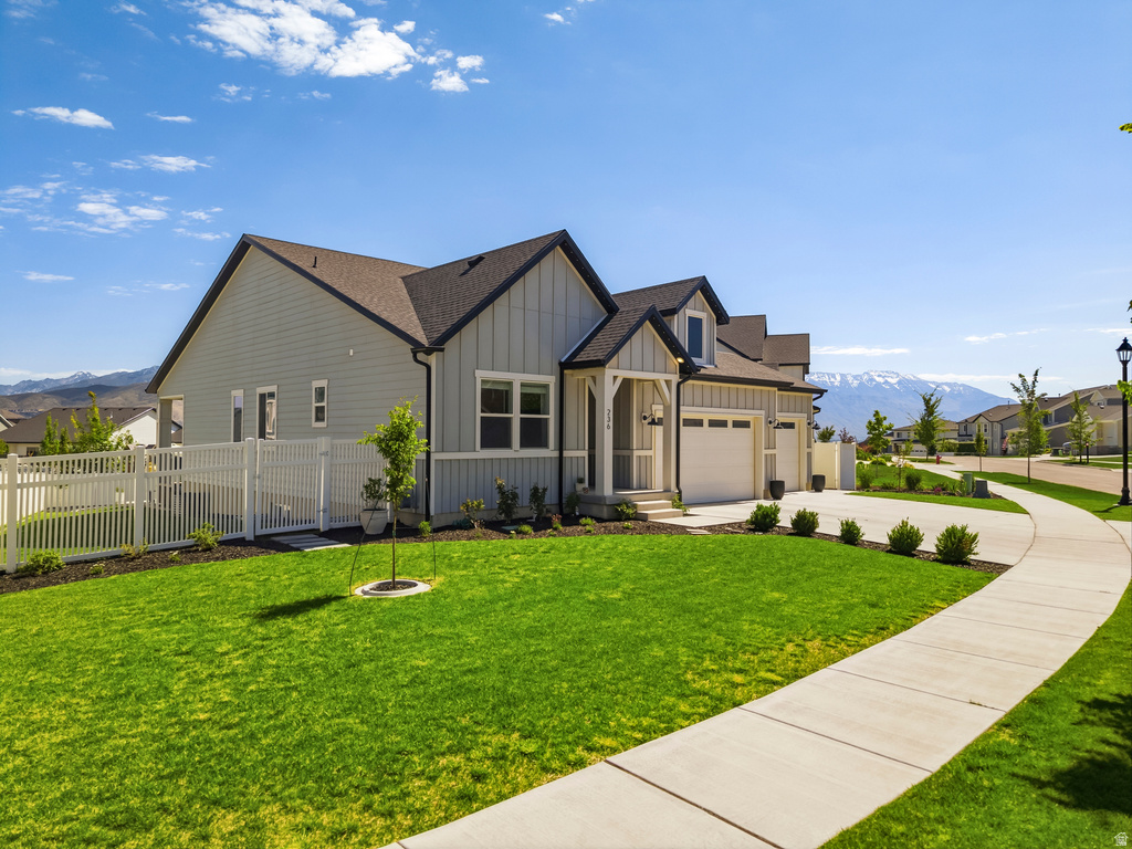 Contemporary home with light gray siding, dark trim, and a prominent front porch