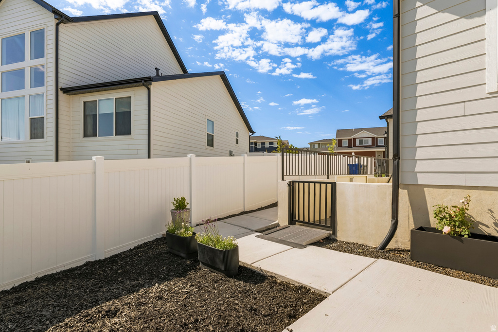 Exterior with light-colored siding, black trim, and a white privacy fence