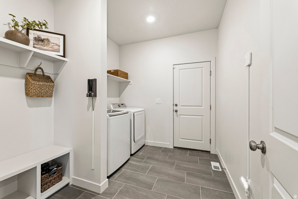 Laundry area featuring large format tile flooring, built-in shelving, and a two-panel interior door