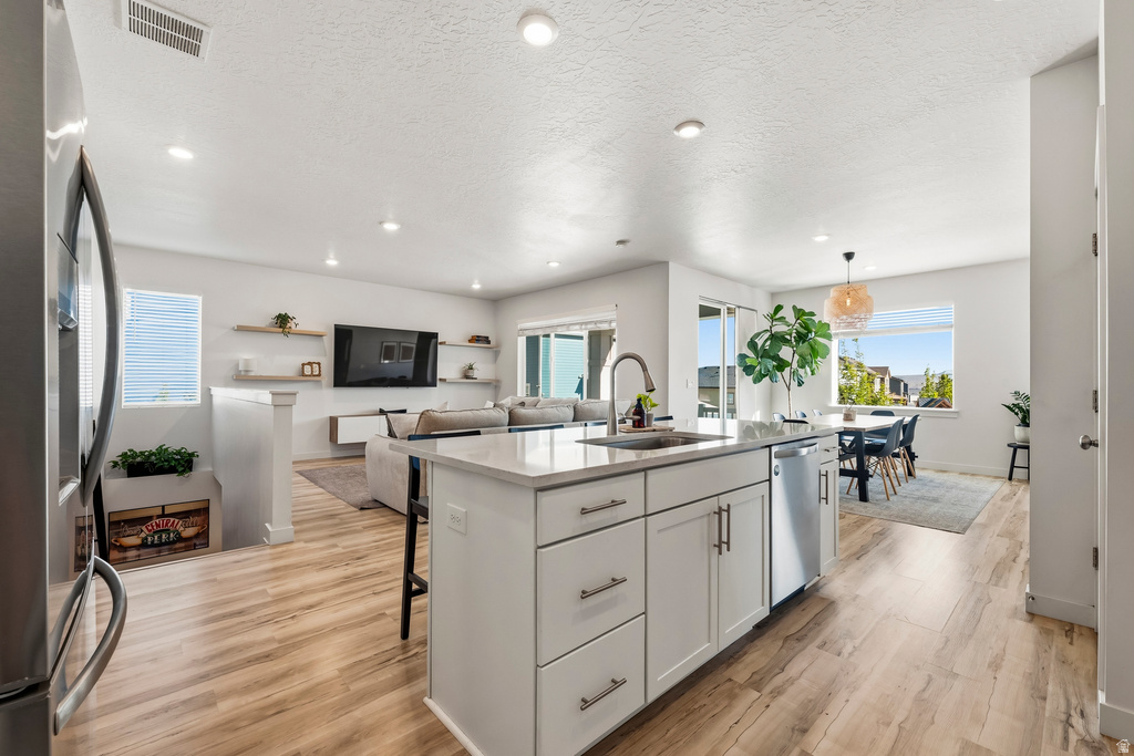 Open-concept interior featuring wood-finish flooring, white walls, and recessed lighting