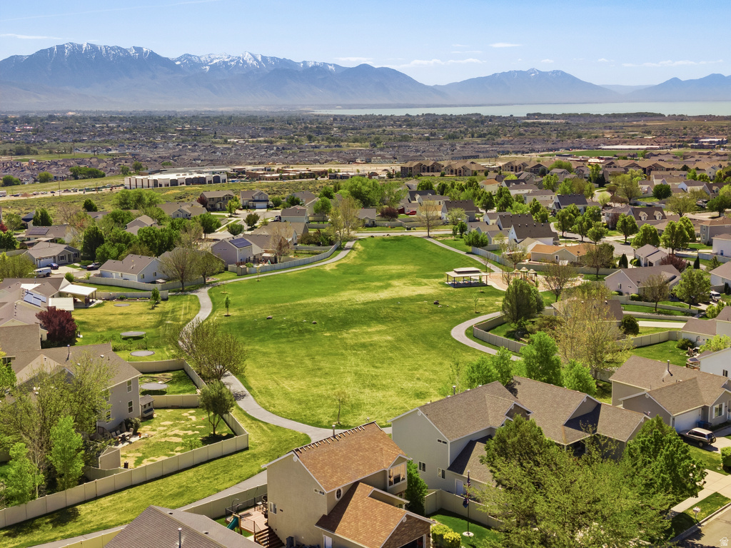 Aerial perspective of a residential neighborhood featuring a central green space with walking paths and mature trees