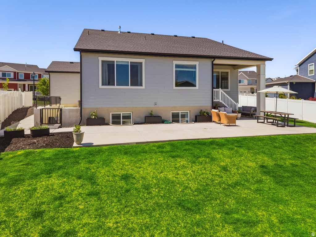 Expansive backyard featuring a lush lawn, a concrete patio, and a covered patio area
