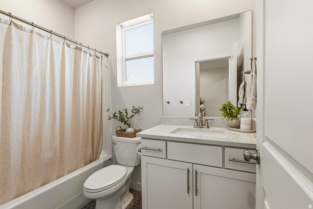 Bathroom featuring a white bathtub, a toilet, and a vanity with a rectangular sink