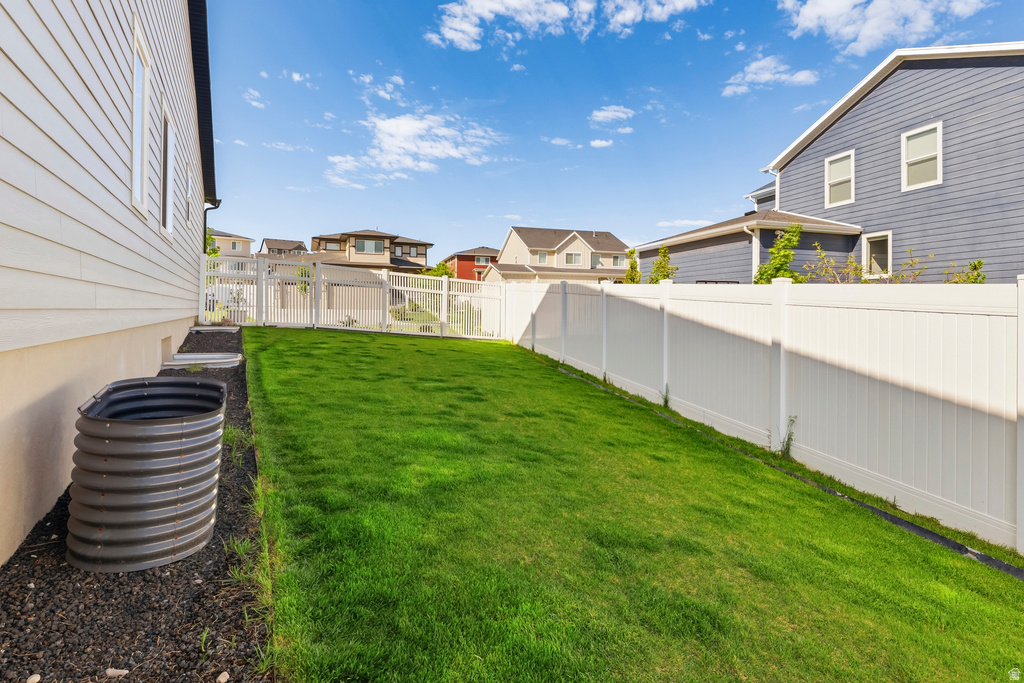 Expansive backyard featuring a lush lawn and a white privacy fence