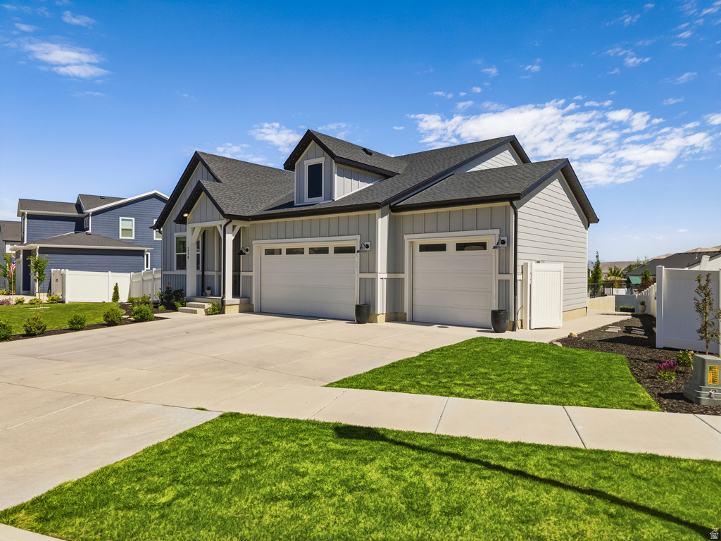 Contemporary two-story residence featuring light gray siding and a dark shingle roof