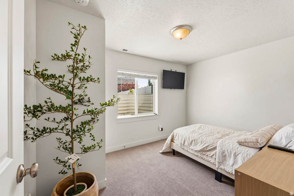 Carpeted room with a single window and recessed lighting