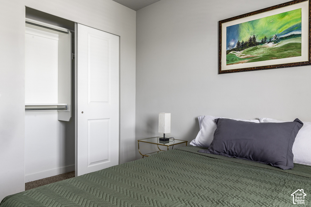Bedroom featuring neutral wall paint, carpeted flooring, and a built-in closet with bi-fold panel doors and an interior hanging rod