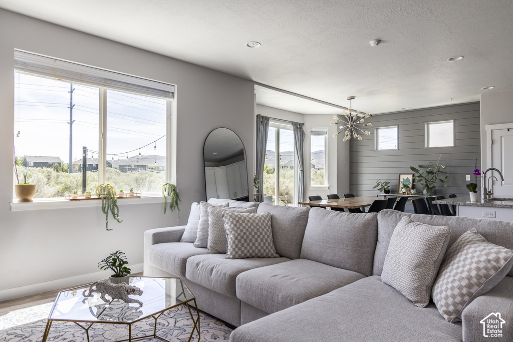 Open-concept living area with wood-finish flooring, recessed lighting, and a prominent window