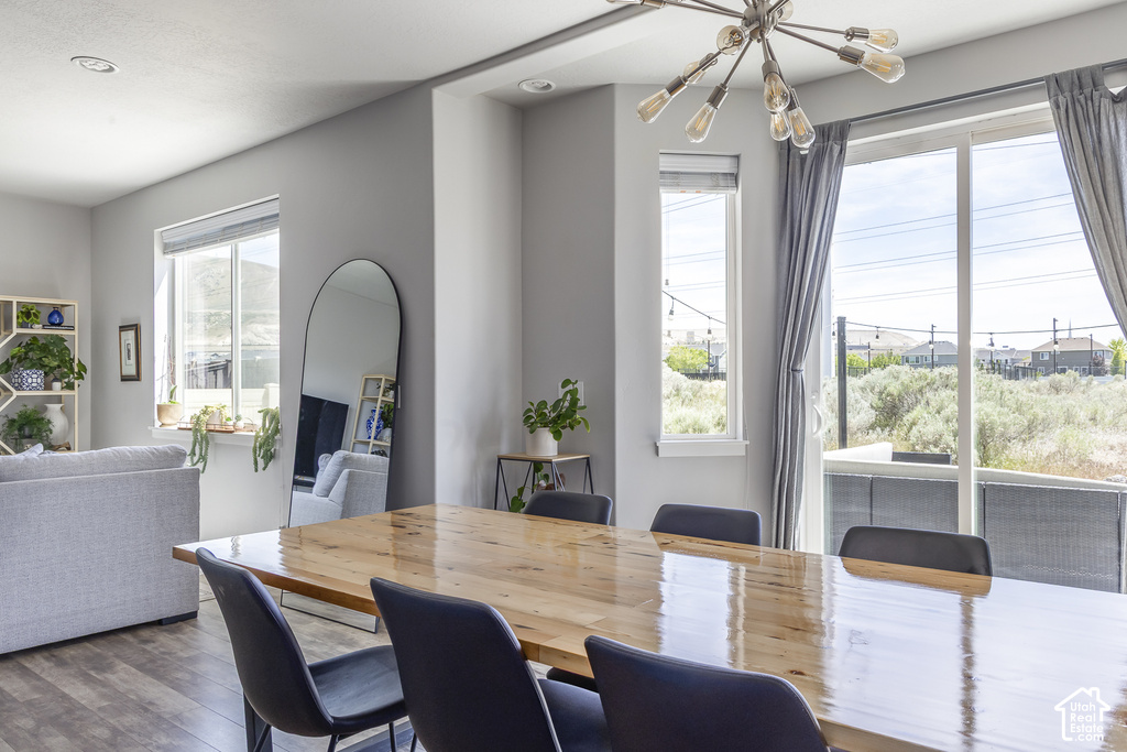 Open-concept dining area featuring a wood-finish dining table and a contemporary chandelier