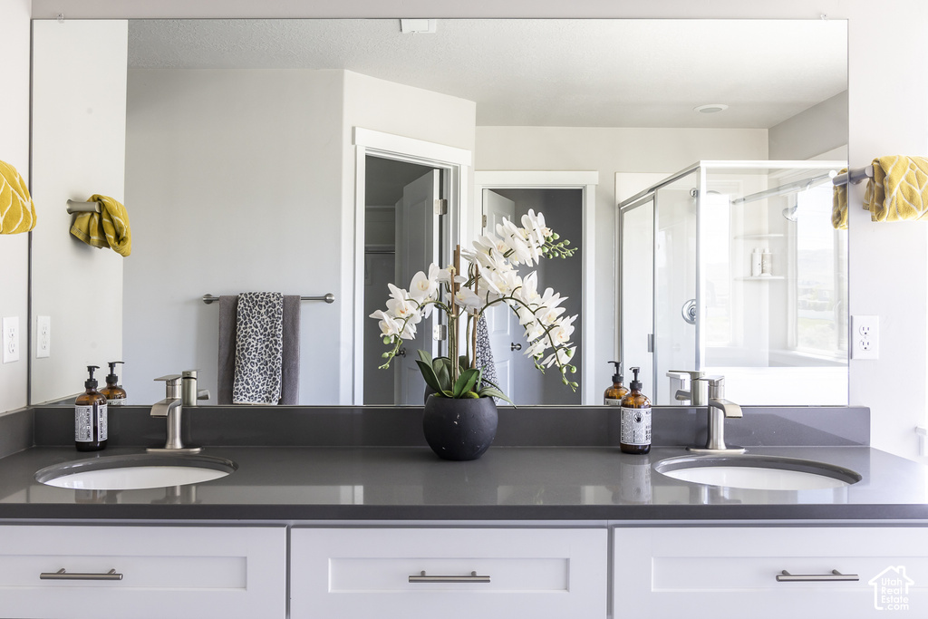 Dual undermount sinks set into a dark gray countertop, featuring brushed nickel faucets and a wide mirror