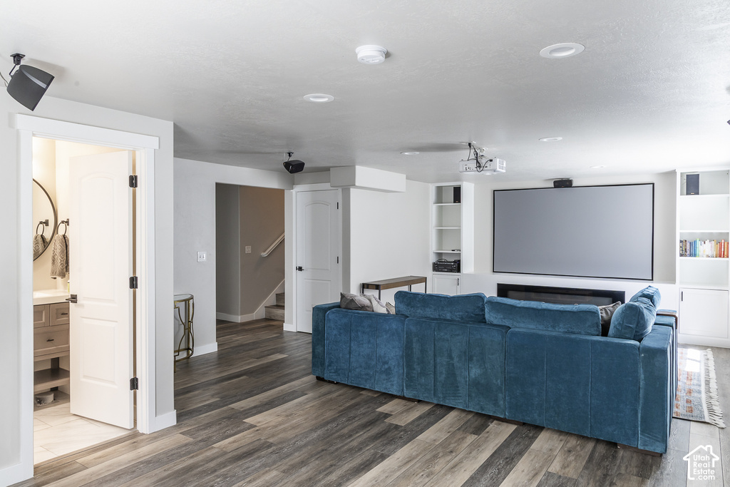 Entertainment room featuring a large projection screen, built-in shelving, and a wall-mounted fireplace