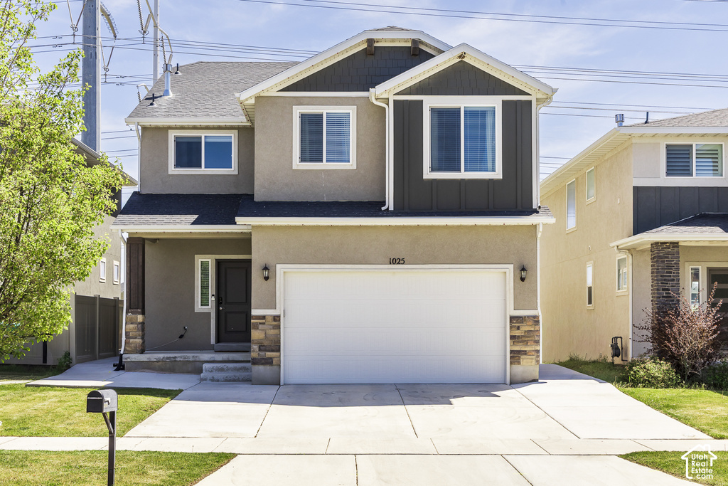 Contemporary two-story residence featuring a two-car garage, stucco exterior, and stone accents