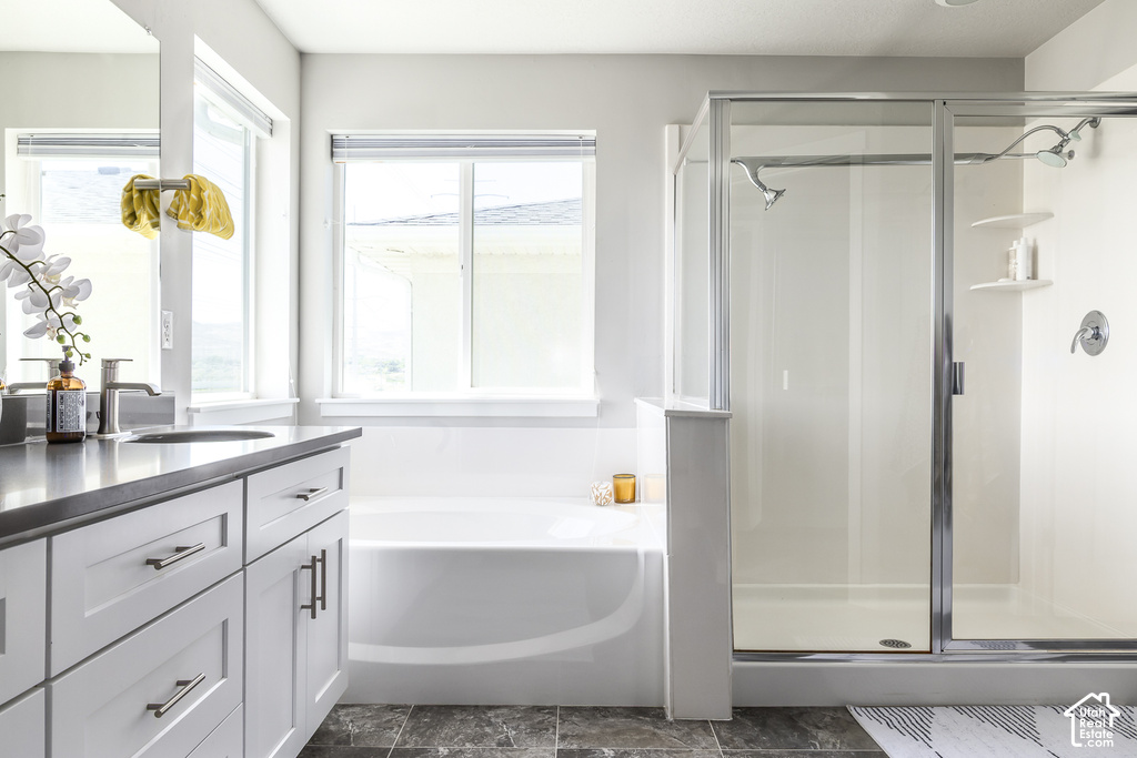 Contemporary bathroom featuring a white vanity with brushed nickel hardware, a built-in bathtub, and a glass-enclosed shower