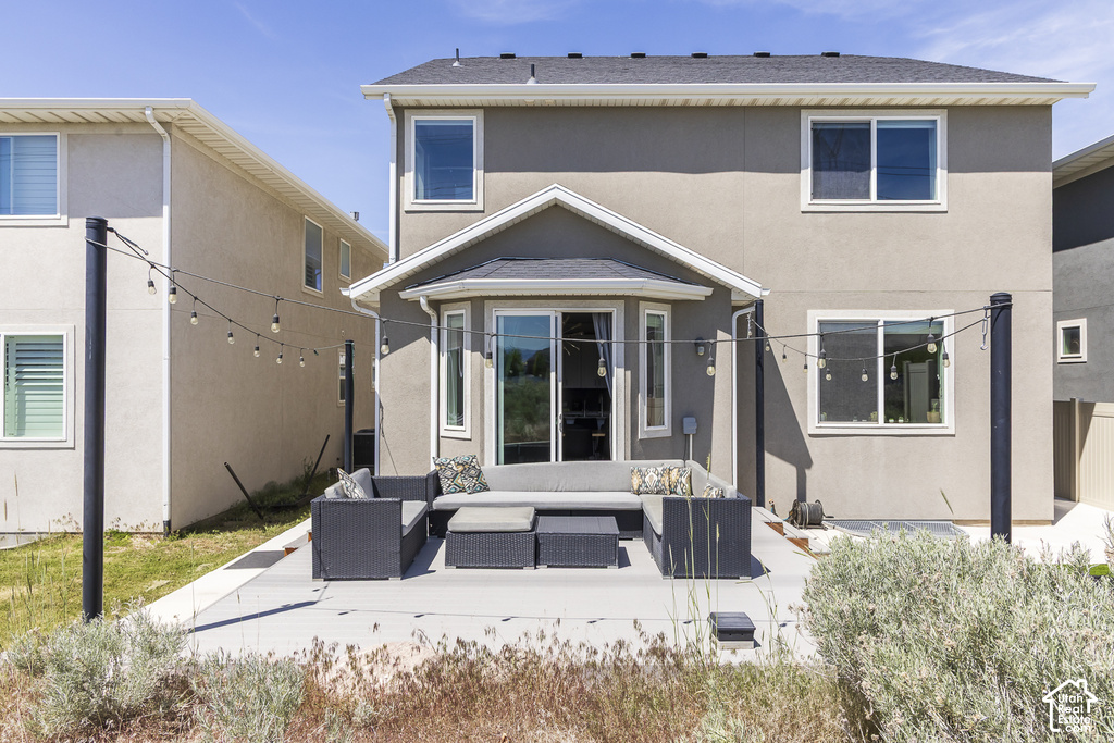 Rear exterior featuring a concrete patio, sliding glass door, and multiple windows