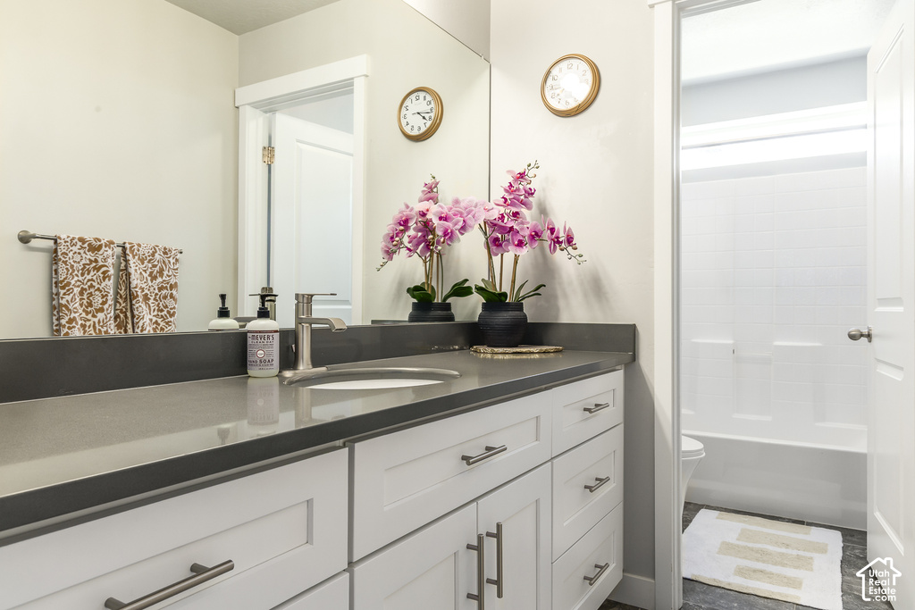 Bathroom featuring a wide vanity with a gray countertop, an undermount sink, and a single-handle faucet