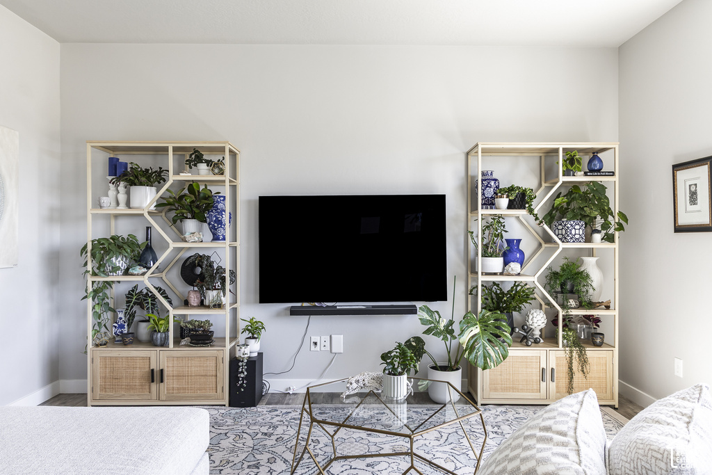 Living area featuring two built-in shelving units with geometric accents and lower rattan-front cabinetry