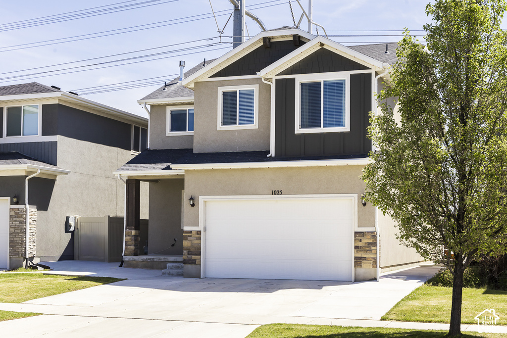 Contemporary two-story residence featuring a two-car garage, stucco siding, and stone accents