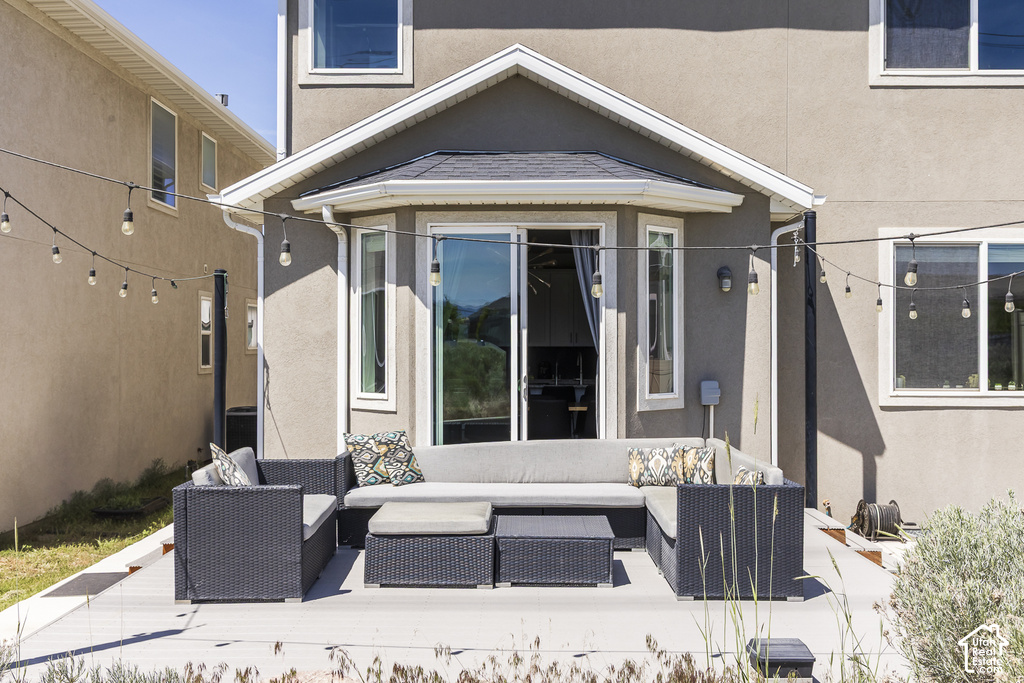 Spacious outdoor deck with a sliding glass door entry, an architectural bay window feature, and a gray stucco exterior