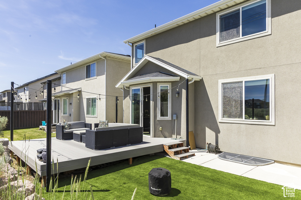 Expansive composite deck featuring string lighting and a stone retaining wall