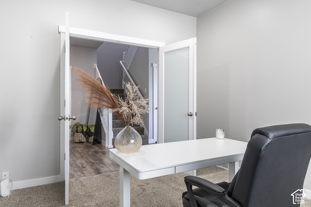 Double doors with frosted glass panels open into a versatile space featuring neutral wall paint, white trim, and light-toned carpeting