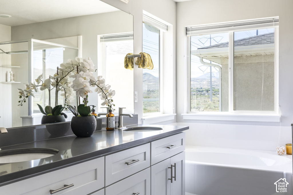 Double vanity with a dark countertop, white cabinetry, and brushed nickel hardware