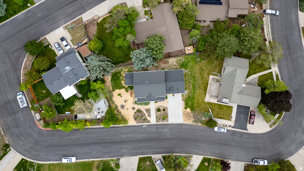Aerial perspective showcasing a residential property with an asphalt driveway and mature landscaping