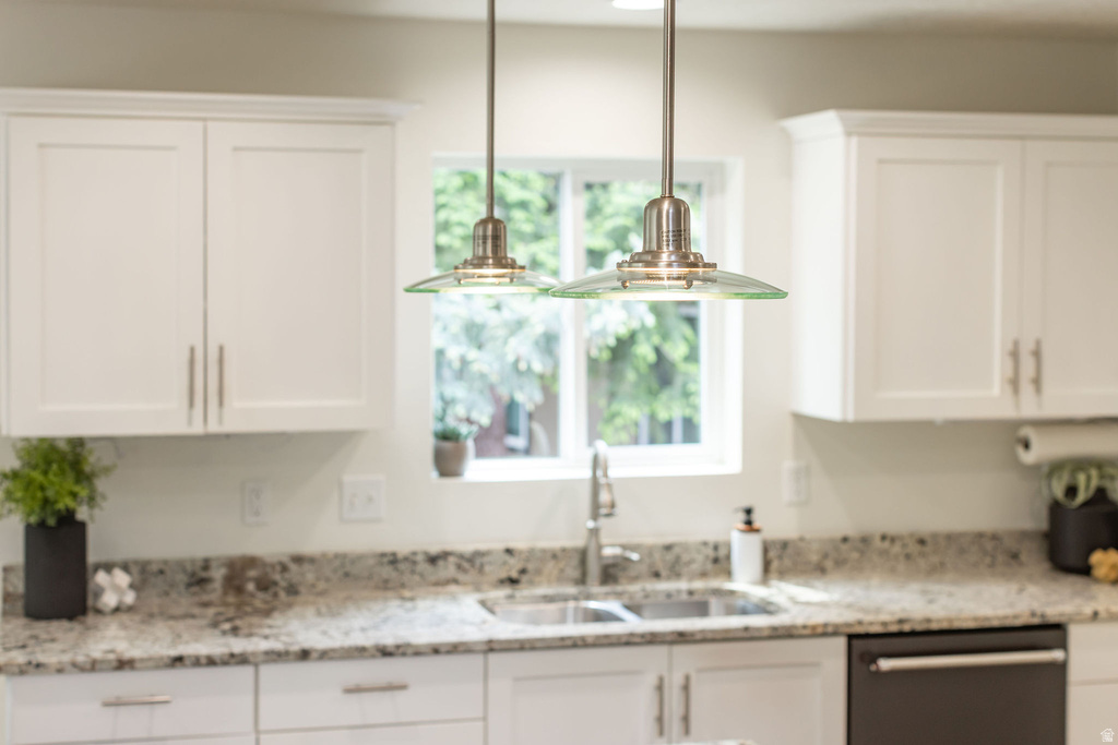 Kitchen featuring white shaker cabinetry, granite countertops, dual basin stainless steel sink with a gooseneck faucet, and two glass pendant lights