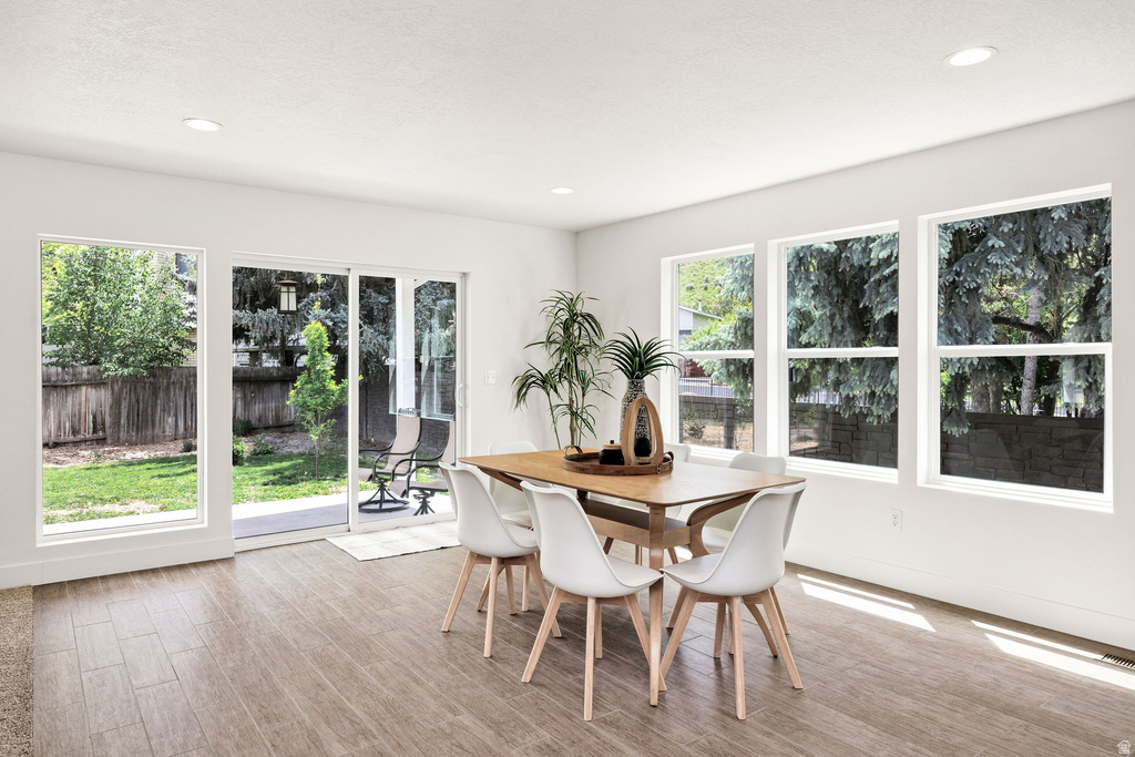 Dining area with wood-finish flooring, recessed lighting, and white walls