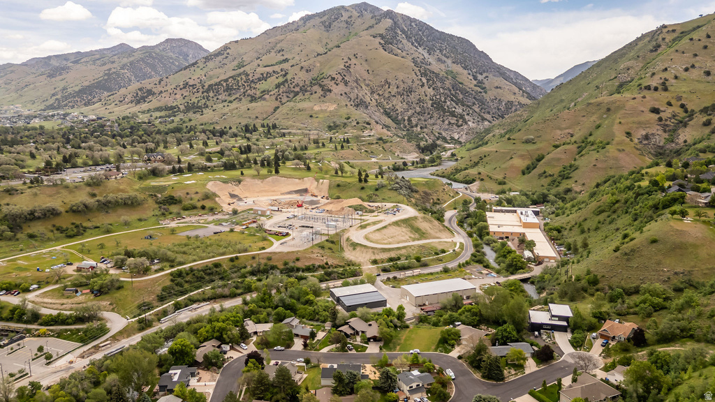 Expansive aerial perspective showcasing a mountainous terrain with lush green slopes and a meandering river