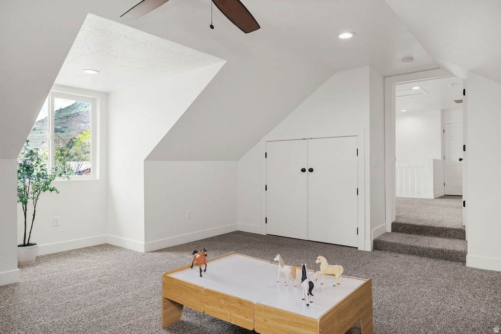 Upper-level room featuring angled ceilings, recessed lighting, and a neutral carpet finish