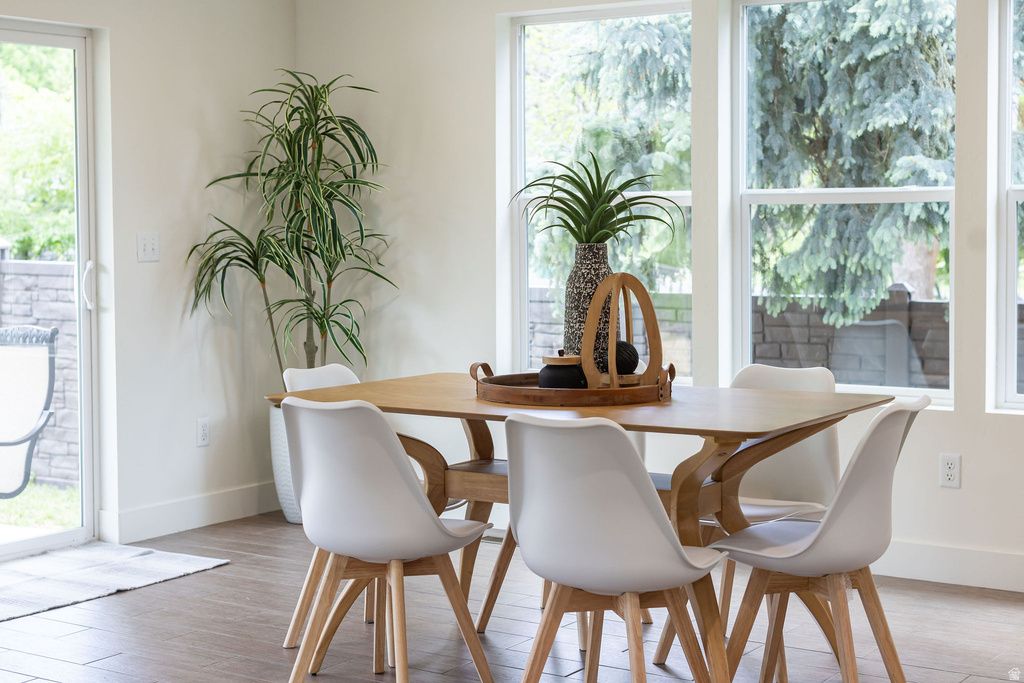 Dining area with wood-finish flooring, white walls, and a sliding glass door