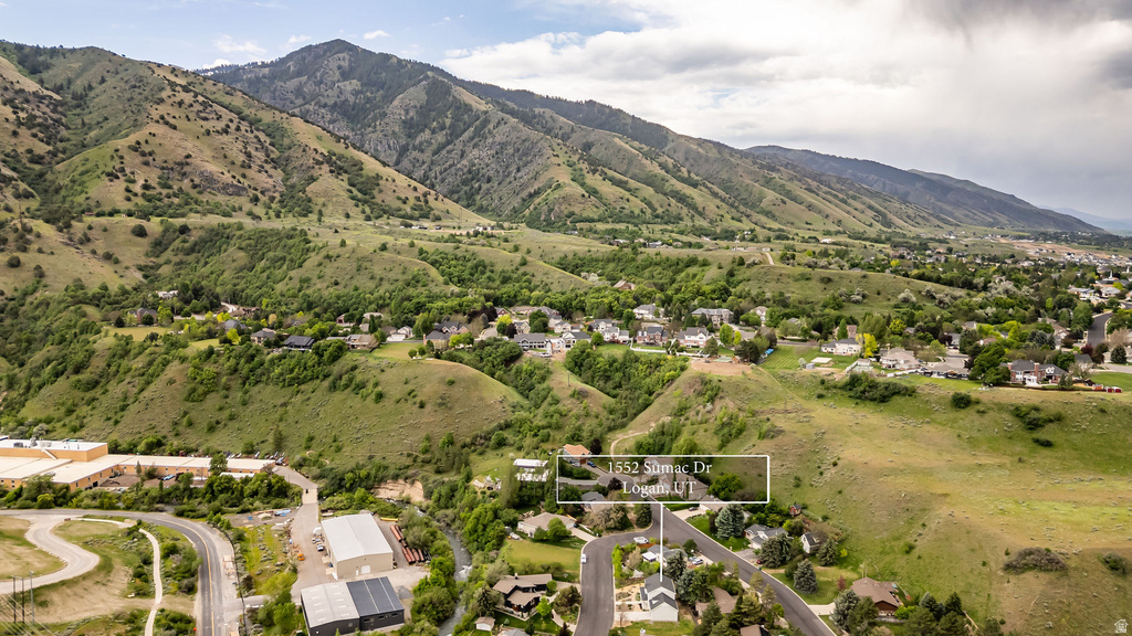 Property situated within a mountain landscape, featuring residential structures and extensive green hillsides